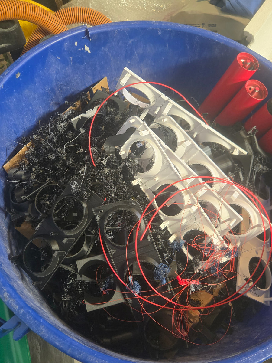 A bin full of failed iterations and support material — every part that ships represents the ones that didn't.